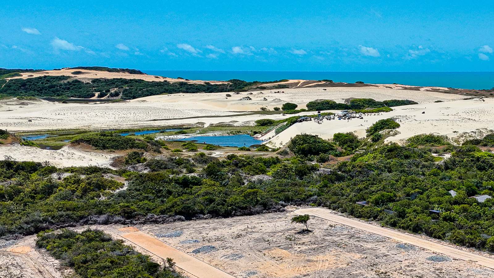 Dunas, lagoa natural e o mar vistos dos lotes