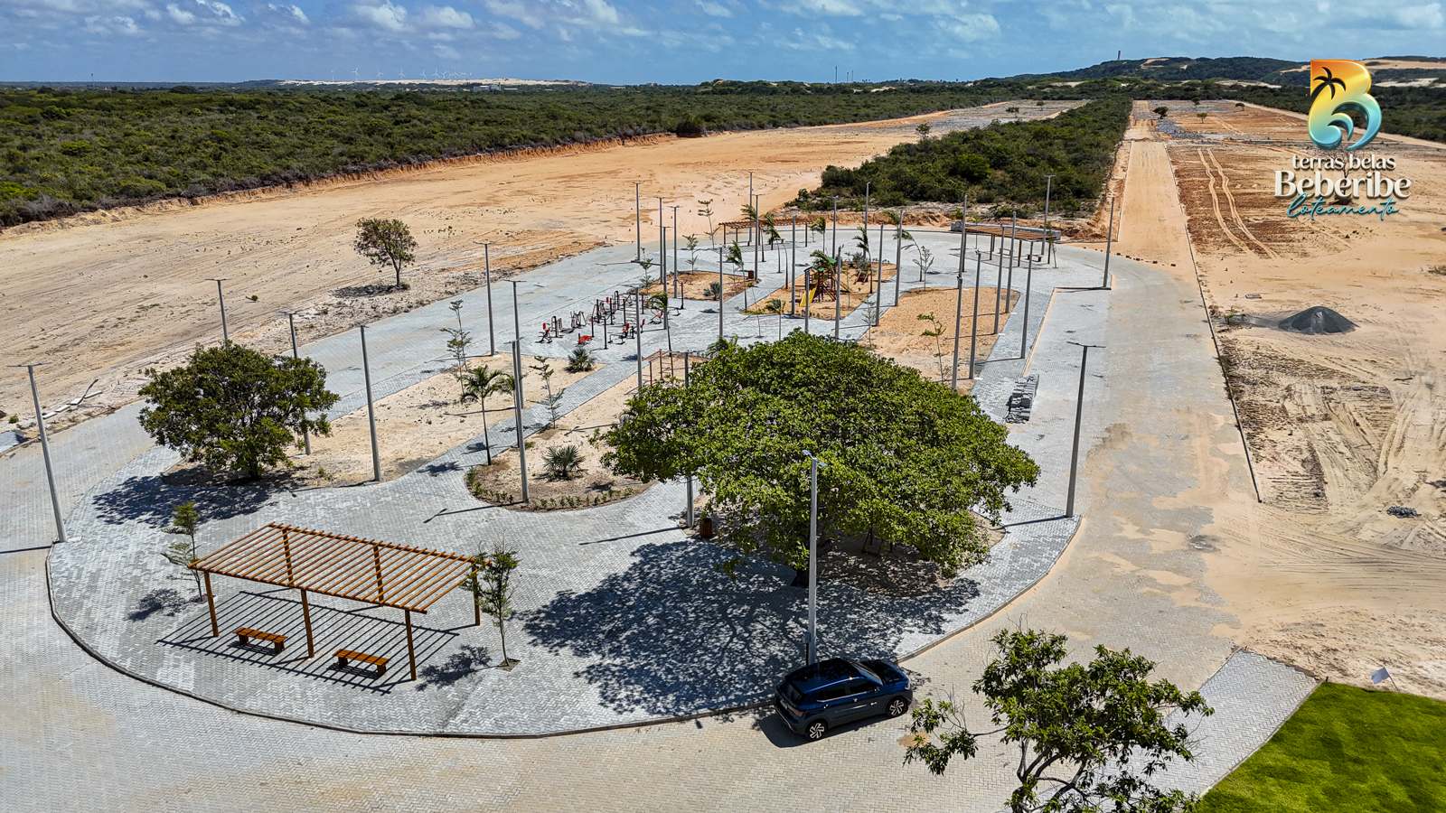 Praça central do loteamento com as dunas ao fundo